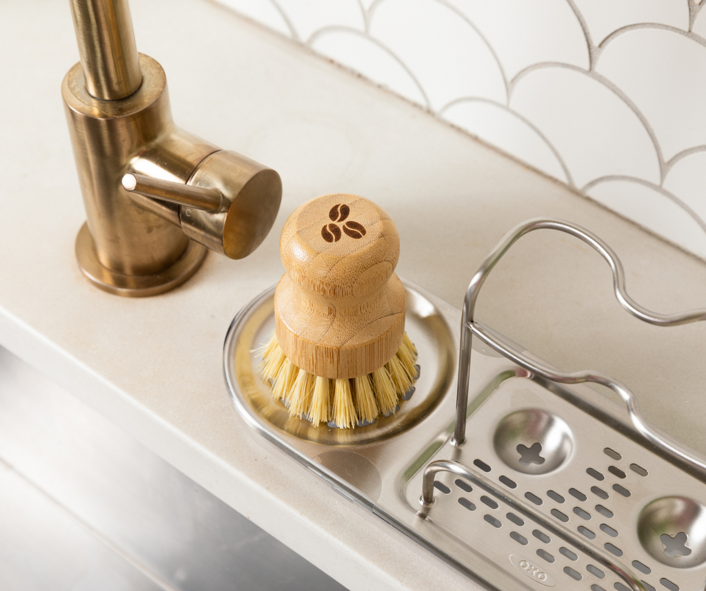 Bamboo scrubber sitting in holder next to kitchen sink